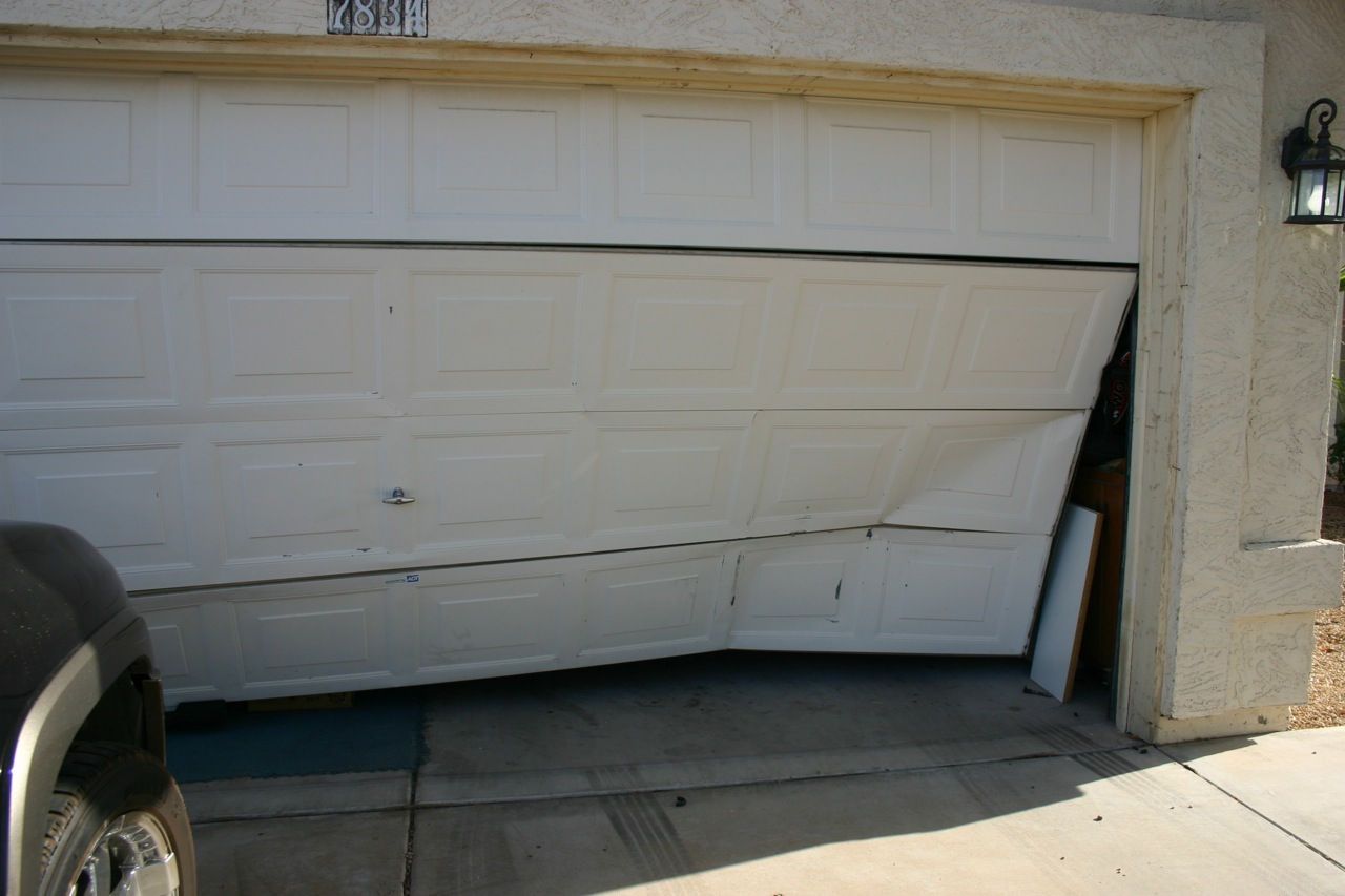 Damaged and wrecked garage door in need of an emergency fix